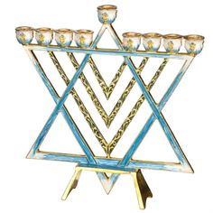 a blue and gold star of david candle holder with six candles in it's center