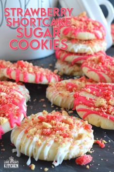 strawberry shortcake sugar cookies with white frosting and sprinkles on top