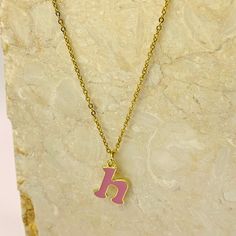 Add a touch of personality and whimsy to your look with our Personalized Pink Initial Necklace. This charming necklace features a custom letter of your choice, crafted with a gold-plated finish and filled with vibrant pink enamel. The delicate chain complements the playful letter, creating a cheerful and eye-catching piece. Perfect for everyday wear or as a gift, this necklace is a delightful way to express your unique style. Trendy Personalized Rose Gold Charm Necklaces, Enamel Initial Pendant Necklace As Gift, Trendy Initial Pendant Charm Necklace For Mother's Day, Trendy Initial Pendant Necklace For Mother's Day, Trendy Gold Charm Necklaces For Personalized Gift, Personalized Gold Enamel Charm Necklace, Pink Initial Pendant Jewelry For Mother's Day, Enamel Initial Pendant Jewelry Gift, Trendy Initial Necklace With Letter Beads As Gift