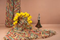 a vase with yellow flowers sitting on top of a table next to a decorative object