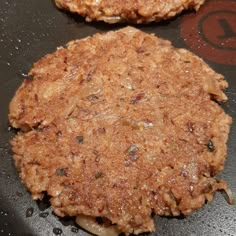 two hamburger patties sitting on top of a frying pan next to each other