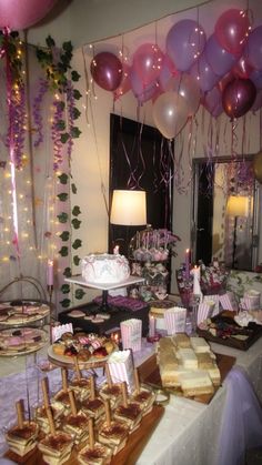 a table filled with lots of desserts and balloons