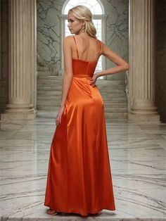 a woman in an orange dress standing on a marble floor with her back to the camera