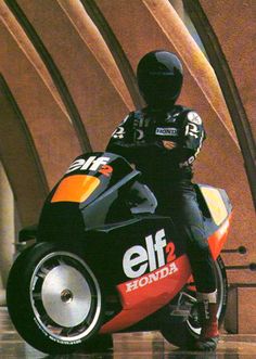 a man riding on the back of a motorcycle down a wet floor next to a wall