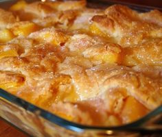 a casserole dish with peaches in it sitting on a wooden table top