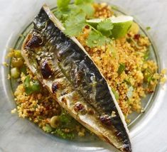 two fish on a plate with rice and cilantro