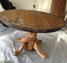 an old wooden table sitting on top of a white sheet