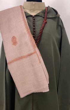 Introducing the Nur Sandala Shawl, a stunning piece that features 25 sacred Sandala patterns meticulously hand-embroidered across the fabric. The Nur Shawl is 12-inch wider than our popular Zayn Shawl, offering even more elegance and versatility. Crafted from premium soft wool, this shawl is woven in Kashmir using traditional mechanized looms, producing five to six scarves daily. Each piece is hand-dyed, and the intricate embroidery is done by skilled farmer-artisans in the villages, utilizing t Transitional Embroidered Pashmina Shawl, Embroidered Pashmina Shawl For Transitional Seasons, Traditional Pashmina Dupatta With Embroidered Border, Eid Embroidered Pashmina Fabric With Border, Traditional Resham Embroidery Pashmina Shawl, Traditional Shawl With Embroidered Border, Traditional Embroidered Pashmina Shawl For Wedding, Transitional Pashmina Shawl With Traditional Patterns, Traditional Shawl With Motifs For Eid