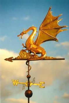 a golden dragon weather vane on top of a building