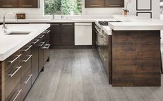 a kitchen with white counter tops and wooden cabinets