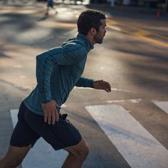 a man is running down the street in shorts