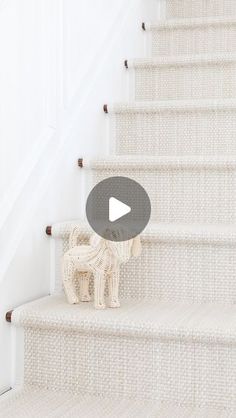 a dog figurine sitting on top of a set of stairs next to a stair case