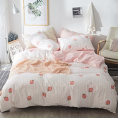 an unmade bed with strawberry print on it