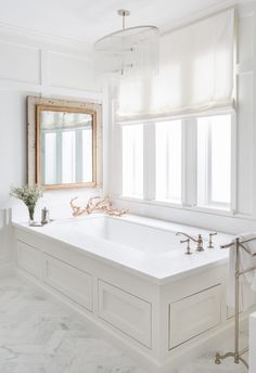 a large white bath tub sitting under a window