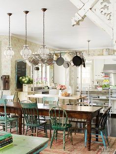 an old fashioned kitchen and dining room with green chairs