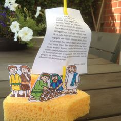 a sponge with an image of people on it and a paper boat in the middle