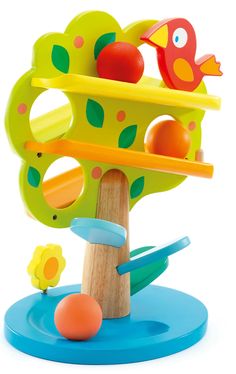 a wooden toy tree with toys in it and an orange bird perched on the top