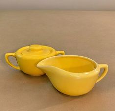 two yellow dishes sitting on top of a table