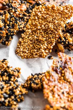 sesame seed crackers are arranged on a piece of parchment paper and sprinkled with seeds