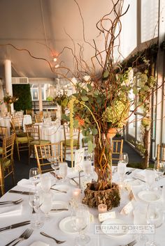 the table is set with white linens and place settings for an elegant dinner party