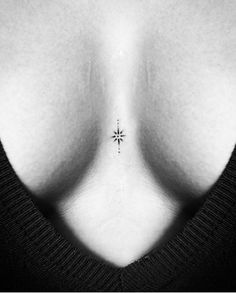 the back of a woman's breast with a small star tattoo on her left side