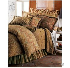 a bed covered in brown and gold comforters