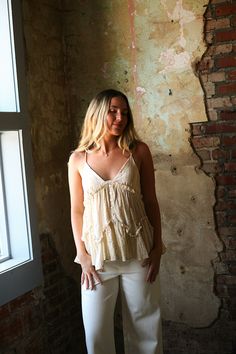 The Daniela Top is like a ray of sunshine - light, airy, and full of playful ruffles. Made with woven cotton gauze and featuring a flattering V-neck, delicate spaghetti straps, and a touch of quirkiness, this top is the perfect addition to your summer wardrobe. Feminine V-neck Camisole With Ruffles, V-neck Ruffled Camisole For Vacation, Beige Ruffled Tank Top For Summer, Cotton Spaghetti Straps Tank Top With Ruffles, Feminine Summer Tank Top With Ruffle Hem, Summer Tops With Lace Trim And Ruffled Straps, Bohemian Ruffled Tank Top For Summer, Flowy Spring Camisole, Chic Ruffled Camisole For The Beach