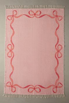 a pink and red rug with an ornate frame on it's side, hanging from the wall