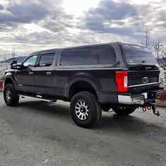 a large black truck parked on the side of a road