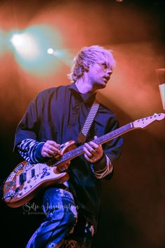 a man playing an electric guitar on stage