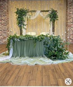 a table covered with greenery and draped cloth