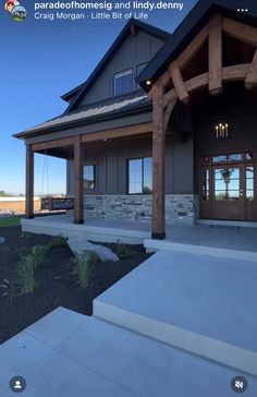 a house that is sitting in the middle of a field with grass and rocks around it