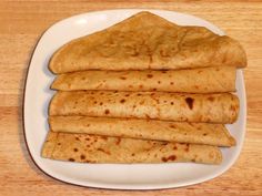 a white plate topped with quesadillas on top of a wooden table