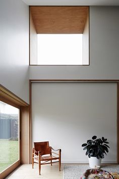 an empty room with a chair and potted plant