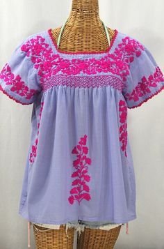 "* Ornate hand embroidery and smocking with hand crocheted trim on the neck and open sleeve hems, available here in PERIWINKLE BLUE with MAGENTA embroidery. * Light, gauzy and semi-sheer 100% cotton throughout; wear it billowy and flowing in the bohemian style, or belted for a more fitted look. * Dyed, distressed  and embroidered by hand for an authentic, retro-vintage and boho-chic hippie vibe.  * Our colorful and ornate floral embroidery patterns are a faithful tribute to the traditional hippi Cheap Bohemian Embroidered Top With Multicolor Embroidery, Cheap Embroidered Peasant Tops, Cheap Casual Embroidered Peasant Top, Cheap Bohemian Peasant Top With Floral Embroidery, Cheap Embroidered Peasant Top For Vacation, Traditional Blue Embroidered Peasant Top, Traditional Blue Peasant Top With Floral Embroidery, Blue Embroidered Folk Peasant Top, Blue Embroidered Peasant Top With Short Sleeves