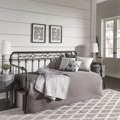 a bedroom with a metal bed and white walls