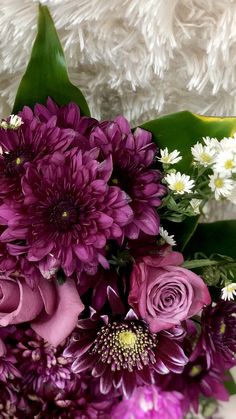 a bouquet of purple flowers sitting on top of a table