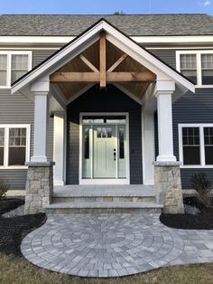 a gray house with white trim and pillars