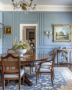 an elegant dining room with blue walls and antique furniture, including a chandelier