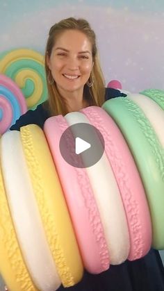 a woman standing in front of a bunch of fake doughnuts