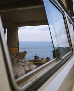 there is a view from the inside of a vehicle looking out at the ocean and land