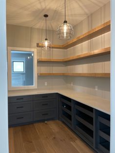 an empty room with wooden shelves and hanging lights