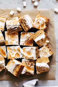 marshmallows and graham crackers are arranged on a piece of parchment paper