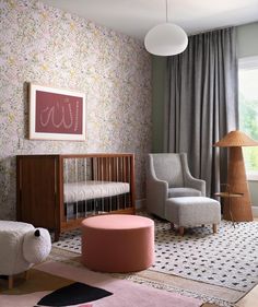 a baby's room with floral wallpaper, pink and gray furniture, and a large window