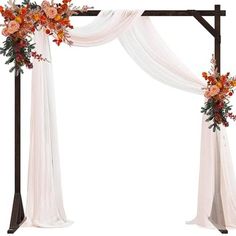 an arch decorated with flowers and white drapes