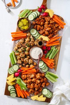 a platter filled with meat, veggies and dip