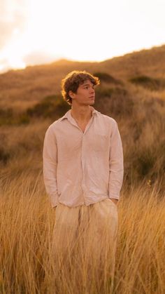 a man standing in tall grass with his eyes closed