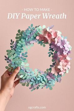 someone holding up a paper wreath with flowers on it and the words how to make diy paper wreath