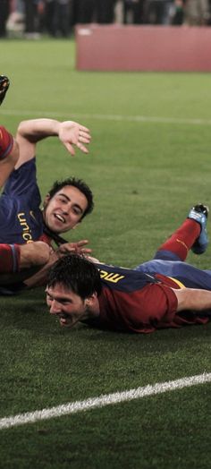 two men on the ground playing soccer with one man falling to the ground and another laying down