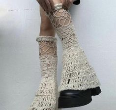 a woman's legs with crocheted socks and boots on top of them